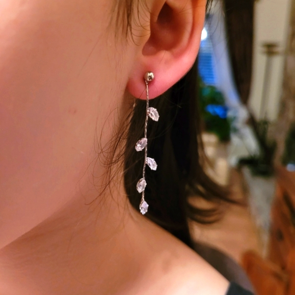Elegant, simple crystal silver color metal dangle earrings with plastic backing.